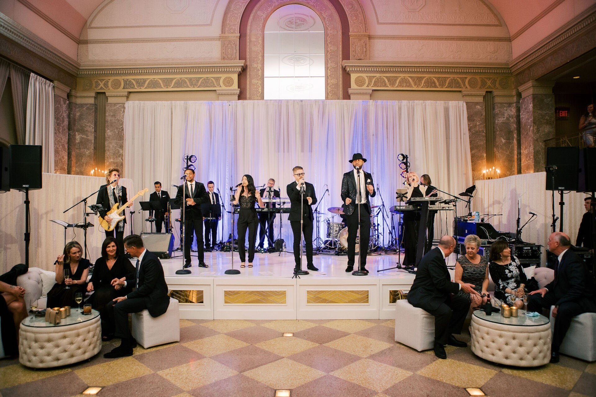 Wedding band playing in the front of an elegant, marble ballroom