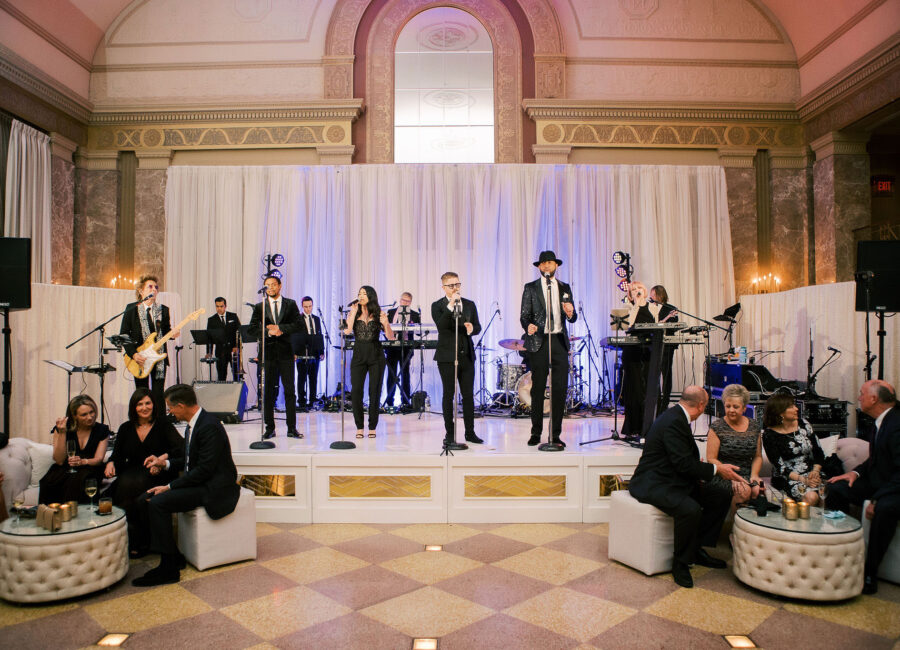 Wedding band playing in the front of an elegant, marble ballroom